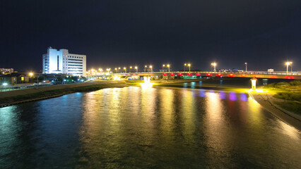 Obraz premium Modern houses and illuminated bridge on the riverside Ural in city Atyrau timelapse hyperlapse