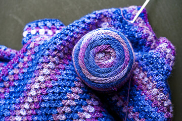 Top view of multi colored acrylic knitting and crochet ball against anthracite colored background...