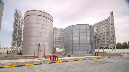 Two big silver Water Tanks with fence timelapse