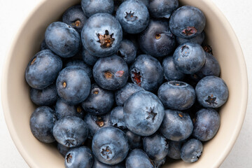 Close-up top view of blueberries in a bowl on the marble surface