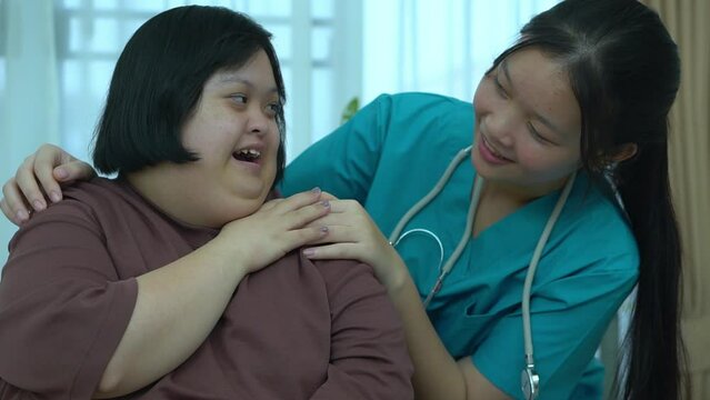 Asian female doctor Supporting patients with Dow Syndrome at home.