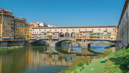 Fototapeta premium The Ponte Vecchio on a sunny day timelapse, a medieval stone segmental arch bridge over the Arno River in Florence, Italy