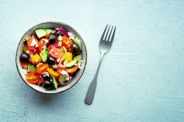 Greek salad. Fresh tomato, cucumber, bell pepper, Feta cheese, onion, and olives. Healthy summer food, overhead flat lay shot, with copy space