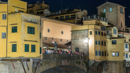 Famous Ponte Vecchio bridge over the Arno river timelapse in Florence, Italy, lit up at night