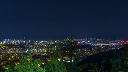 Obraz premium Fatih Sultan Mehmet Bridge view, connects Asia and Europe night timelapse from top of Camlyca hill. Istanbul, Turkey