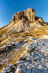 Sextenstein mountain - Sasso di Sesto - illuminated by a brilliant golden sun at golden hour sunset in early autumn on a bright sunny day next to the Dolomite landmark Tre Cime di Lavaredo