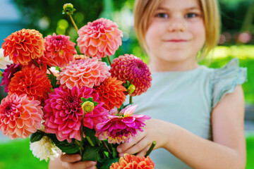 Close up of little preschool girl with dahlia flower bouquet. Close-up of happy child holding...