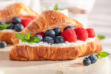 Golden and healthy french croissant with blueberries and raspberries.