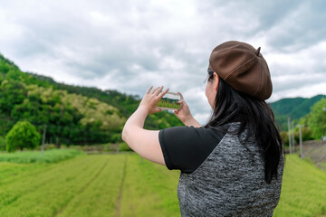 Woman Capturing Nature's Beauty on Smartphone