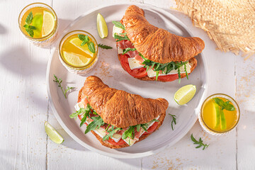 Fresh and homemade french croissant with camembert, prosciutto and tomatoes.