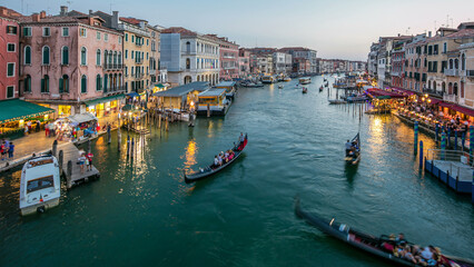 Grand Canal in Venice, Italy day to night timelapse. Gondolas and city lights from Rialto Bridge.