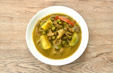 spicy boiled slice beef meat with eggplant in coconut milk green curry soup on plate