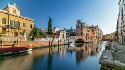 Morning in Venice timelapse. Canal and bridges, historical old houses and boats. Venice, Italy