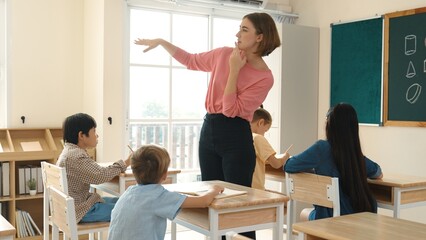Caucasian teacher teaching and explaining theory to multicultural student by using body gesture...