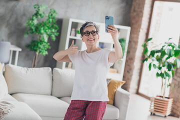 Photo of pretty retired woman video call thumb up wear white outfit home flat rest relax spend free...