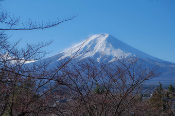 A distant view on Mt Fuji in Japan on a clear,The top parts of the volcano are covered with a layer of snow.