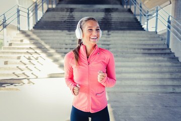 Exercise, music and a sports woman running in the city for health or cardio preparation of a...