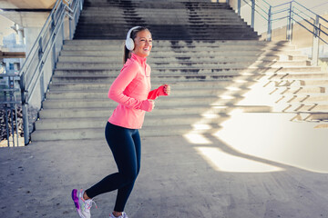 Woman running. Female runner jogging, training for marathon. Fit girl fitness athlete exercising outdoor. Photo of young woman running on sidewalk in morning. Health conscious concept with copy space.
