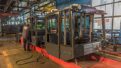Conveyor assembly stage the body of tractor at big industrial factory timelapse