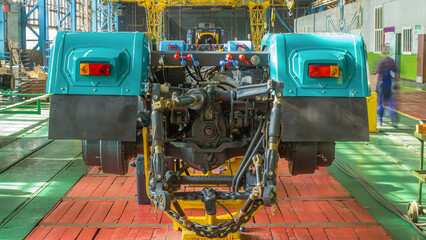 Conveyor assembly stage the body of tractor at big industrial factory timelapse