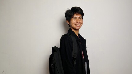 college young asian man happy while carrying bag