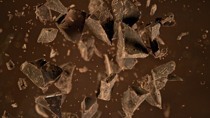 Freeze motion of flying group of raw chocolate pieces.