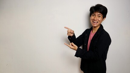 excited young asian man wearing cool denim shirt posing pointing to the side