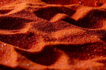 Small bright orange crystals of potassium dichromate, closeup, abstract colorful background