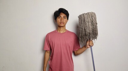 young asian man poses holding a mop