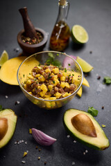 Cooking traditional tuna and mango tartare - chopped and mixed tuna, mango, cilantro and onion in a...