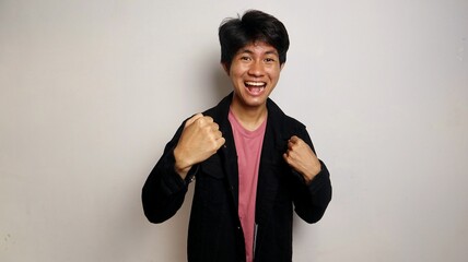 young asian man excited pose raising his hands