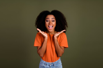 Portrait of overjoyed funny girl with wavy hairstyle wear orange t-shirt staring at unbelievable...