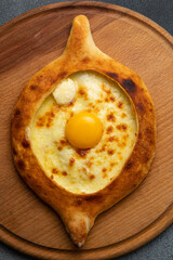 Georgian khachapuri with egg yolk on wooden board