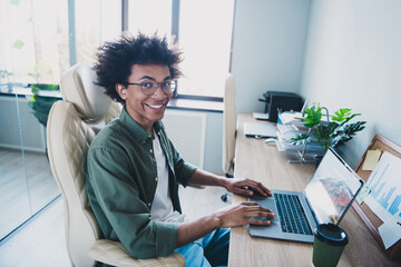 Photo of handsome cool assistant dressed khaki shirt glasses sending emails modern gadget indoors...