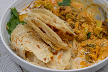 Vegan Indian korma made with seitan and coconut cream, served with paratha flat breads.