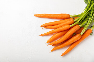 Carrots on a textured wooden background. Fresh and sweet organic carrots on a white background. Carrot slices. Vegan. Ingredients for salad. Place for text. Copy space. Flatley