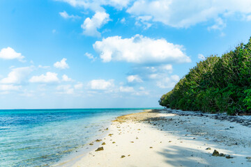 沖縄県竹富島まぶしい砂浜、青い空、透き通る緑の海