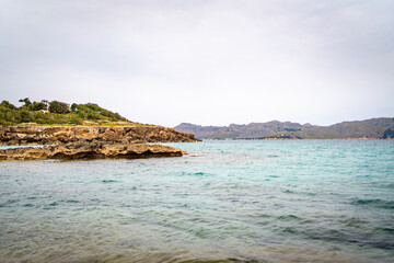 sea side shore in la victoria town in mallorca spain on a chilly day - blue waters and blue sky