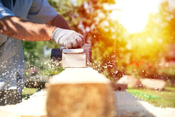 a carpenter works with an electric pipe on a sunny day