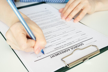 Divorce agreement, hand fills out a document, legal proceedings, signing the decree, ending the...