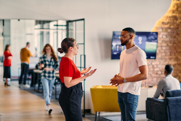 Young business colleagues, including an African American businessman, engage in a conversation...