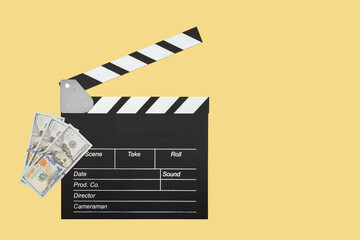 Film clapper and cash, movie-making costs, media industry spending. Video clapperboard and dollars,...