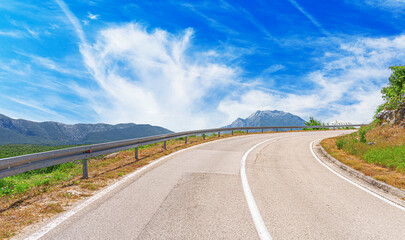 Country road with rocky mountains in the background.