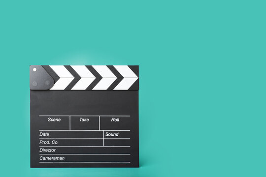 Cinema clapper board on a green background, copy space, film production, director's essential tool, setting the scene.