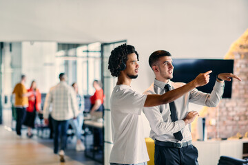 A group of colleagues, including an African American businessman and a young leader in a shirt and...