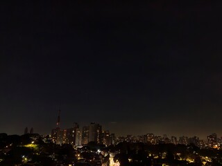 Fotos aéreas noturnas da cidade  de São Paulo, com seu arranha-céus e transito intenso