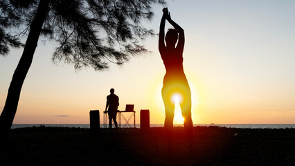 Girl on the beach dancing to music at sunset