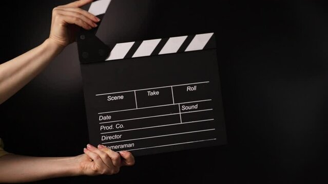 Hands with film clapper, directing the scene, entertainment industry at work.