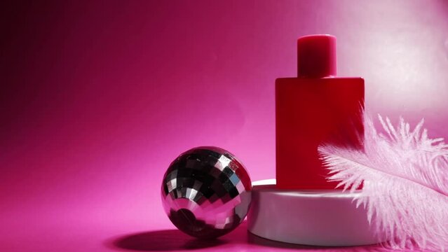 pink perfume on the podium with a soft feather and party disko ball, modern cosmetic, trendy spray, bright essence
