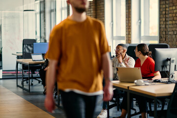 A diverse group of young business individuals congregates in a modern startup coworking center, embodying collaborative innovation and a dynamic atmosphere.